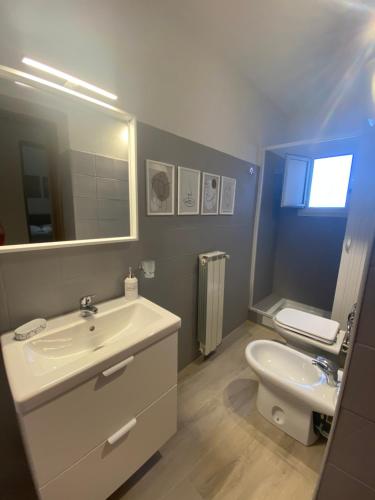 łazienka z umywalką, toaletą i lustrem w obiekcie Home Demetra w mieście Agrigento
