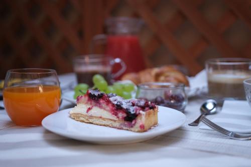 a piece of cake on a plate with grapes and orange juice at Hotel Tahiti in Viareggio
