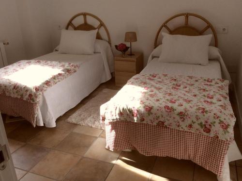1 dormitorio con 2 camas y mesa con lámpara en Puente Romano, en Galizano