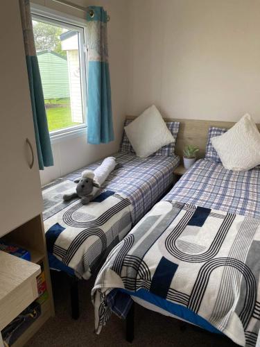 a bedroom with two beds with a teddy bear on them at 32 Elm Walk in Whitley Bay