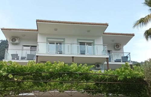 a house with balconies and palm trees at Olive Garden Villas and Apartments in Chrysi Ammoudia