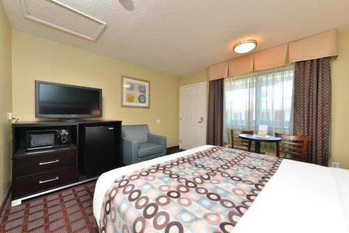 a hotel room with a bed and a flat screen tv at Avenue Inn Downtown District SLO in San Luis Obispo
