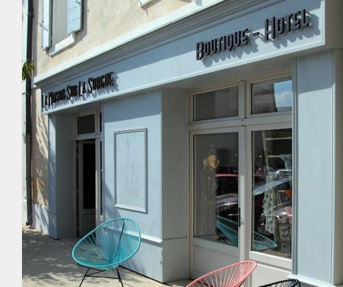 a store with three chairs sitting outside of it at La Maison Sur La Sorgue - Esprit de France in LʼIsle-sur-la-Sorgue
