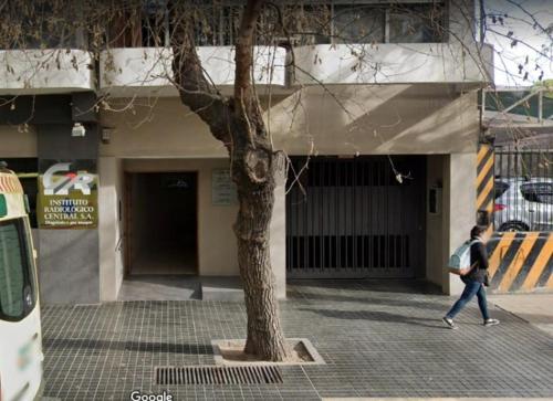 een persoon die langs een boom voor een gebouw loopt bij Departamento Garibaldi 239 in Mendoza