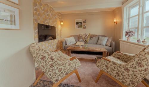 Hellur的住宿－Authentic Faroese House / Unique Location / Nature，客厅配有两把椅子和一张沙发
