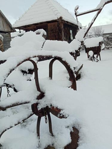 a bench covered in snow in front of a house at Pension Bud in Onceşti
