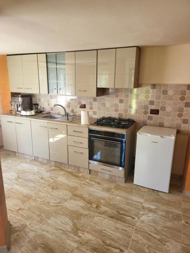 a kitchen with white cabinets and a stove at Pension Bud in Onceşti