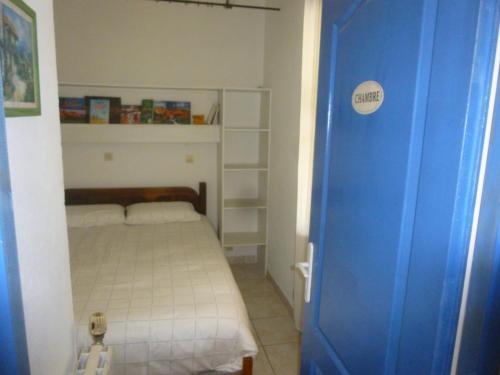 - une petite chambre avec un lit et une porte bleue dans l'établissement PROVENCE SOLEIL LUBERON PISCINE, à Apt