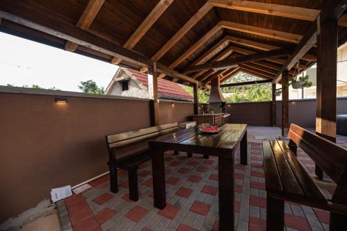 a patio with benches and a table and a roof at Lucija in Starigrad-Paklenica