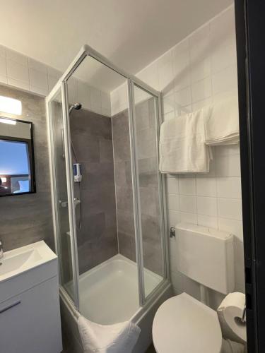 a bathroom with a shower with a toilet and a sink at Hotel Casa Andalucia in Hallbergmoos
