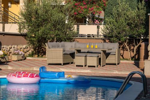 a pool with a table and chairs and a raft in the water at Lucija in Starigrad-Paklenica