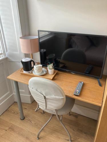 a desk with a monitor and a chair and a television at 'Bloomfield' at stayBOOM in Lancaster
