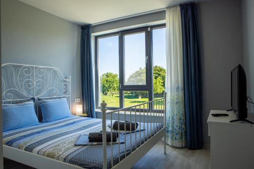een slaapkamer met een bed en een groot raam bij Luxury apartment Vodolei in Krapets