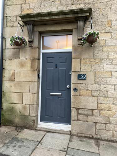 a blue door on a brick building with flowers at 'Bloomfield' at stayBOOM in Lancaster