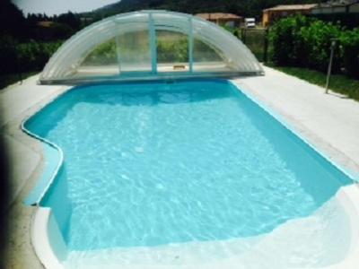 a blue swimming pool with a cover on top of it at villa Soleil 3chambres piscine in Lagorce