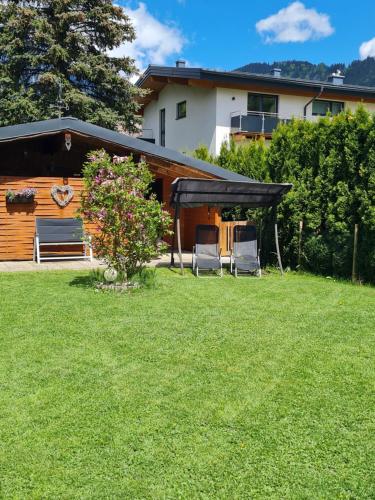 un patio con 2 sillas y una casa en Gästehaus Gamsblick en Werfenweng