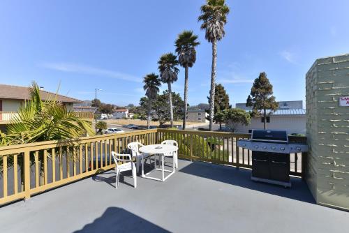 a patio with a grill and a table and chairs at Bay View Inn - Morro Bay in Morro Bay
