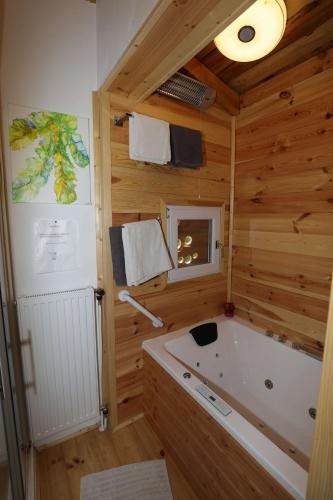 ein Holzbadezimmer mit einer Badewanne und einem Fenster in der Unterkunft Baumhaus in Imbach