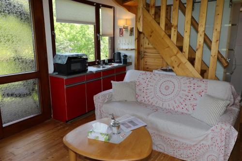 una sala de estar con un sofá y una mesa en Baumhaus, en Imbach