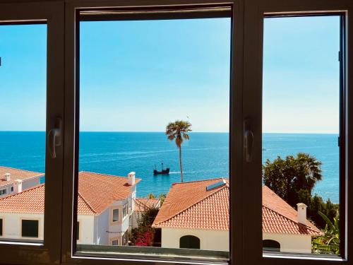 a view of the ocean from a window at Ocean Cliffs Apartments in Funchal