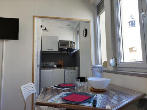 - une petite cuisine avec une table et un comptoir dans l'établissement Les lumières du phare, à Calais