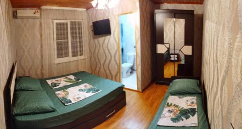 a small room with two beds and a bathroom at Guest House on Rechnaya 14G in Lidzava