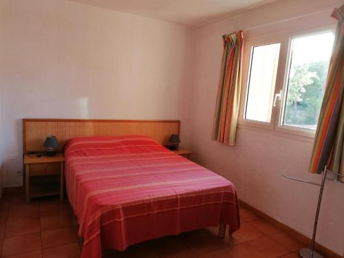 une petite chambre avec un lit et une fenêtre dans l'établissement Appartement les pieds dans l'eau 300 m plage - 2 piscines, à Linguizzetta