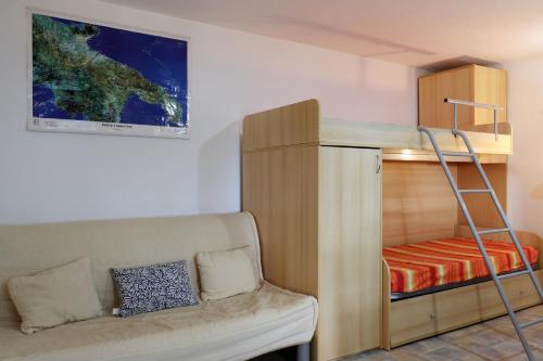um beliche num quarto com um sofá e uma escada em Grazioso Monolocale della Casa dell'Olivo em Salve