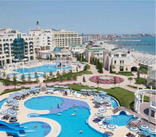 an aerial view of a resort with pools and umbrellas at "Красавиците тъмнокоси" Sunset Resort Pomorie in Pomorie