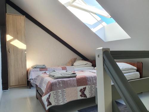a attic bedroom with two beds and a staircase at Pokoje Gościnne Świnoujście Łunowo in Świnoujście