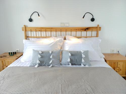 a bedroom with a bed with white sheets and pillows at Sea Lilies Suites in Plaka