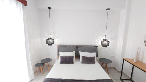een slaapkamer met een groot bed en 2 stoelen bij Chania Locals in Chania