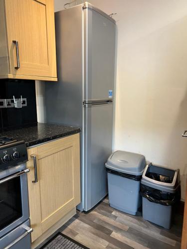 a kitchen with a refrigerator and a trash can at 4 bed bungalow near Airport in Edinburgh