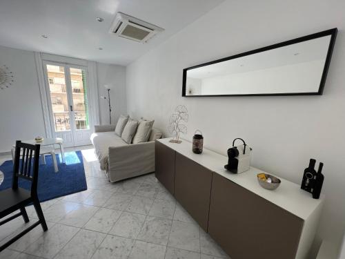 a living room with a couch and a mirror on the wall at Monaco quartier Monte Carlo magnifique 2 pièces in Monte Carlo