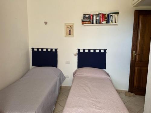 dos camas sentadas una al lado de la otra en una habitación en Casa Souad, a cheerful and charming beach view 2 bedroom house and free parking, en Porto San Paolo
