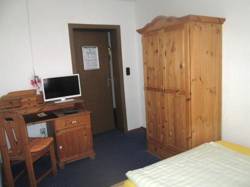 a bedroom with a desk with a computer and a bed at Hotel Haus Frieling in Dortmund