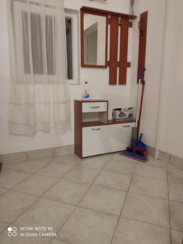 Cette chambre est dotée de carrelage et d'un miroir. dans l'établissement Apartments Jakovljević, à Grebaštica