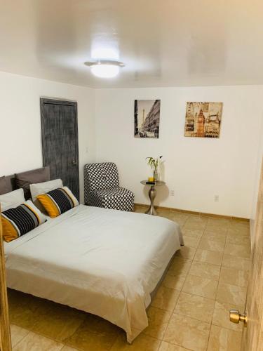 a bedroom with a bed and a chair at El Rincon Amarillo. Zona Dorada. in Tijuana