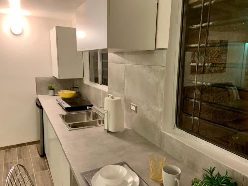 a small kitchen with white cabinets and a sink at El Rincon Amarillo. Zona Dorada. in Tijuana