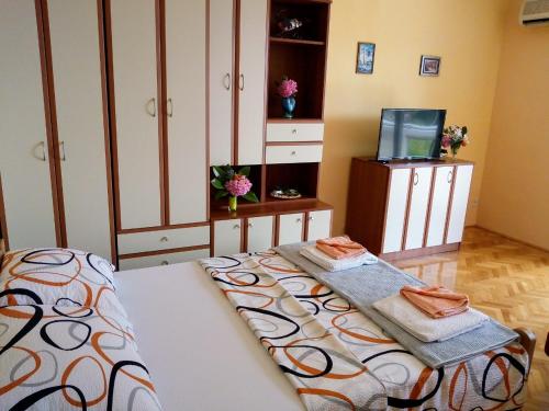 een slaapkamer met een bed en een televisie en kasten bij Savina in Herceg-Novi