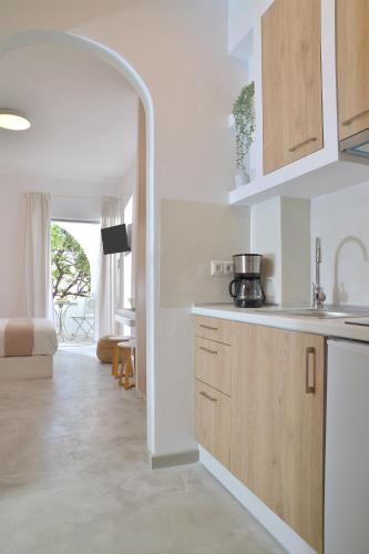 a kitchen with white walls and wooden cabinets at Niriis Studios Aktaia & Glauke Batsi in Batsi