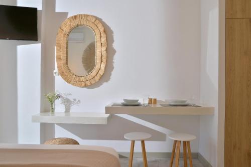 a living room with a mirror and stools at Niriis Studios Aktaia & Glauke Batsi in Batsi