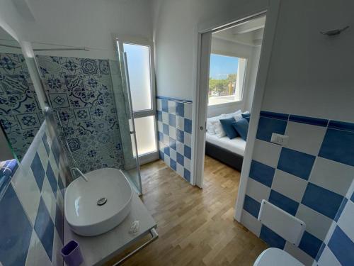 uma casa de banho com um WC, um lavatório e um espelho. em ITINERA Baia Verde Rooms and Breakfast em Gallipoli