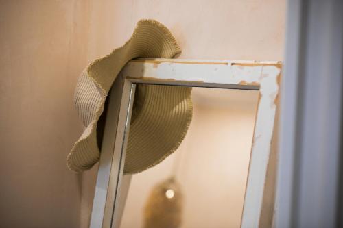 a mirror with a hat on top of it at MORF suites in Casale Marittimo