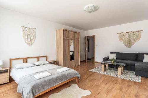 a bedroom with a large bed and a couch at Apartamenty INTERDOM in Zakopane