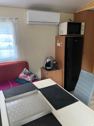 Cette petite chambre dispose d'une table et d'un réfrigérateur. dans l'établissement Mobil home bungalow 6 personnes villeneuve loubet plage marina baie des anges, à Villeneuve-Loubet