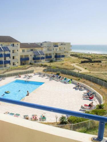 - une vue sur la piscine avec des chaises et l'océan dans l'établissement T3 FRONT DE MER LACANAU OCEAN - 22m2 TERRASSE -2 PISCINES -WIFI-PARKING, à Lacanau-Océan