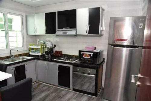 uma cozinha com um frigorífico de aço inoxidável e um micro-ondas em Haut-Standing- Appartement-Fes-City em Fez
