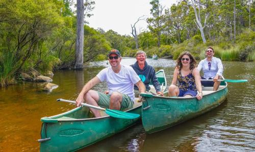 a group of people sitting in kayaks on a river at Villa 11 Margaret River Beach House in Margaret River Town