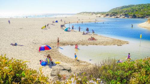 a group of people on a beach near the water at Villa 11 Margaret River Beach House in Margaret River Town